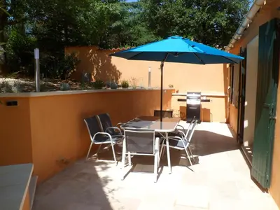 a table and chairs with an umbrella on a patio at Villa Célestine in Roussillon