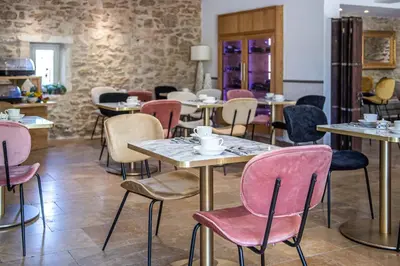 a restaurant with tables and chairs with cups on them at Hôtel Mas Valentine in Saint-Rémy-de-Provence