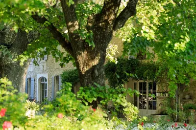 a tree in front of a house with a building at Hôtel Mas Valentine in Saint-Rémy-de-Provence