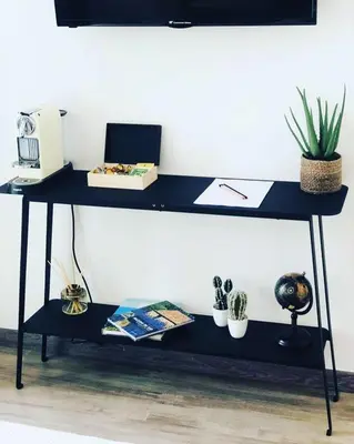a blue desk with a computer and some plants at Appart Hôtel Cézanne in Aix-en-Provence