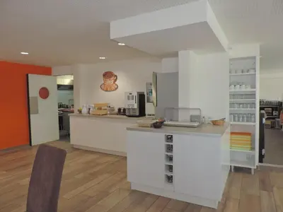 a kitchen with white cabinets and a counter top at Appart Hôtel Cézanne in Aix-en-Provence