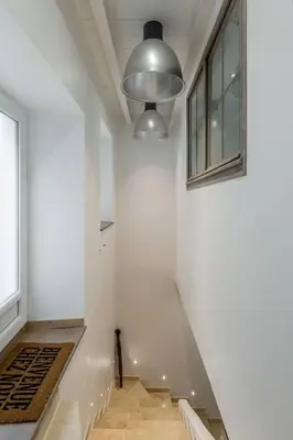 a hallway with a white wall and a window at Petite Maison du Ventoux in Mormoiron