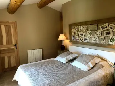 a bedroom with a bed with pillows and pictures on the wall at Splendid Villa in Viens with Swimming Pool in Viens