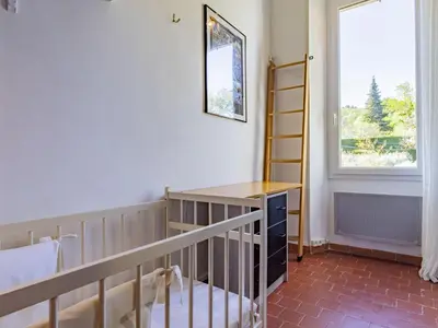 a bedroom with a crib and a window at Holiday Home Bastide du 19ième by Interhome in Oppède