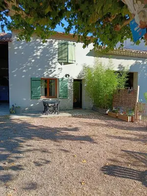 a white house with a bench in front of it at Gîte des deux platanes in Orgon
