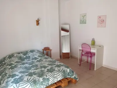a bedroom with a bed and a desk and a chair at Gîte des deux platanes in Orgon