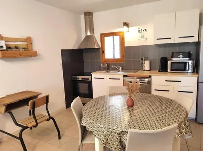 a kitchen with a table and chairs in a kitchen at Gîte des deux platanes in Orgon