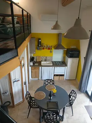 a small kitchen and dining room with a table and chairs at les cerisiers de stella in Blauvac