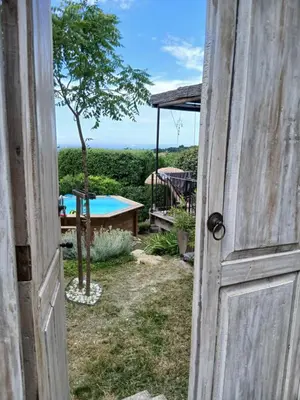 an open door to a backyard with a pool at les cerisiers de stella in Blauvac