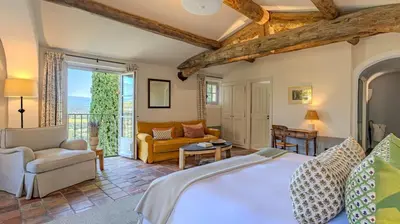 a bedroom with a bed and a living room at Hotel Crillon le Brave in Crillon-le-Brave