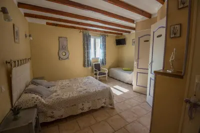 a bedroom with a bed and a living room at Chambres d'Hôtes de Curnier in Bédoin