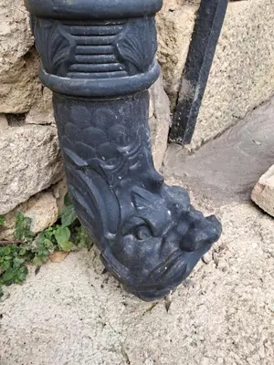 a black statue of a boot on the ground at Le Vieux Moulin de Jouques in Jouques