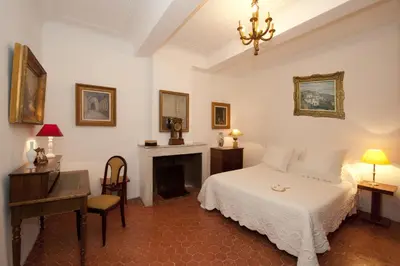 a bedroom with a bed and a desk and a fireplace at La Maison du Peintre en Provence in Mallemort