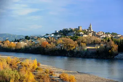 a view of a river with a city in the background at La Maison du Peintre en Provence in Mallemort