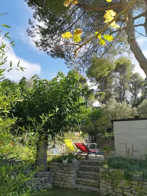 a red and yellow chair sitting in a yard at Le Mas des Anges in Cheval-Blanc