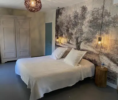 a bedroom with a bed with a painting on the wall at Le Domaine Saint Jean in Saint-Saturnin-les-Apt