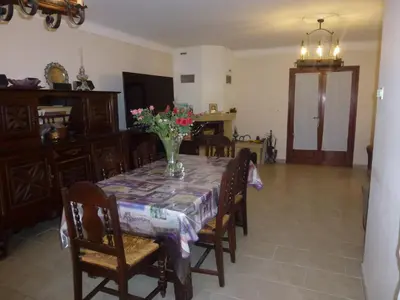 a dining room table with a vase of flowers on it at Chambre d'hôtes La Pinede in Lambesc
