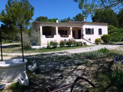 a large white house with a yard with flowers at Chambre d'hôtes La Pinede in Lambesc