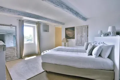 a white bedroom with a large bed and a window at Villa Sunset in Gordes in Gordes