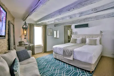 a bedroom with a large white bed and a couch at Villa Sunset in Gordes in Gordes