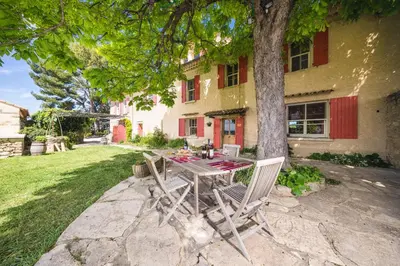 a table and chairs sitting in front of a house at Le Mas de Plein Pagnier in Mazan