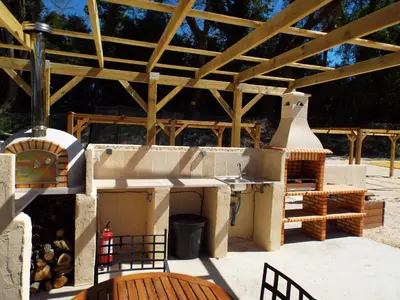 a outdoor kitchen with a grill and a stove at Gîte de Léonie Moulin de Tartay en Avignon in Avignon