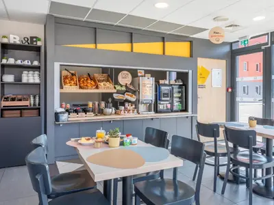 a dining room with tables and chairs and a bakery at B&B HOTEL Aix en Provence Venelles in Venelles
