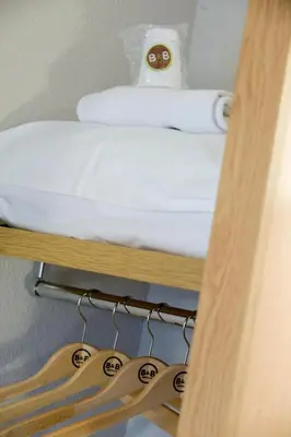 a bunk bed on a shelf with hangers at B&B HOTEL Aix en Provence Venelles in Venelles