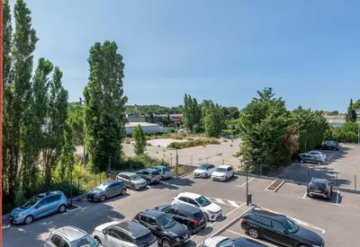 a parking lot full of cars parked in a parking lot at B&B HOTEL Aix en Provence Venelles in Venelles