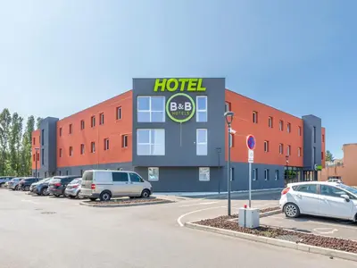 a hotel with cars parked in a parking lot at B&B HOTEL Aix en Provence Venelles in Venelles