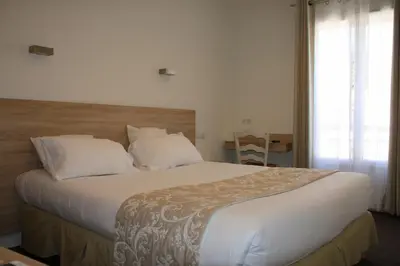 a bedroom with a large bed with white sheets and pillows at Le Concorde in Aix-en-Provence