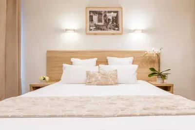 a bedroom with a large white bed with white pillows at Le Concorde in Aix-en-Provence