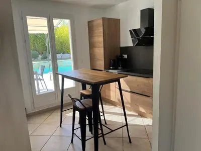 a small kitchen with a wooden table and a counter at Golf de Pont Royal Villa du Lac climatisée 3 chambres Piscine chauffée Parking et Garage in Mallemort