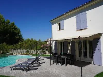 a house with chairs and a swimming pool at Golf de Pont Royal Villa du Lac climatisée 3 chambres Piscine chauffée Parking et Garage in Mallemort