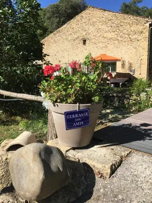 a table with a green umbrella and chairs at Le Mas aux Arômes in Puget