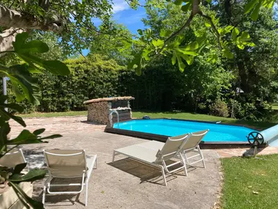 a pool with two chairs and a table and a table and chairs at Le Mas aux Arômes in Puget