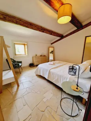 a bedroom with a white bed and a table at Mas du Rollier Chambres d'hôtes in Eygalières