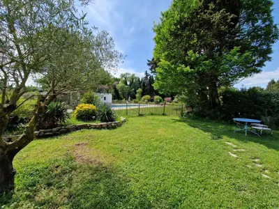 a yard with a picnic table and a fence at Mas du Rollier Chambres d'hôtes in Eygalières
