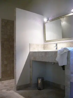 a bathroom with a fireplace with a mirror and a sink at Mas Boudeissoun - Grain de Muscat - Baignade à 600 m in Mormoiron