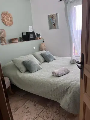 a bed with pillows on it in a bedroom at Maison d'hôtes Bastide St Victor à 2,5 kilomètres de Lourmarin in Puyvert
