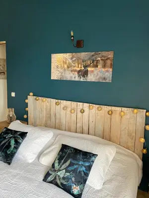 a bedroom with a bed with a wooden head board at Maison d'hôtes Bastide St Victor à 2,5 kilomètres de Lourmarin in Puyvert