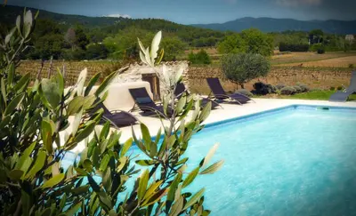 a swimming pool with lounge chairs next to at Maison d'hôtes Bastide St Victor à 2,5 kilomètres de Lourmarin in Puyvert