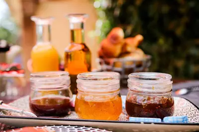 a tray with jars of honey and bottles of juice at Le Mas de la Lombarde in Lourmarin