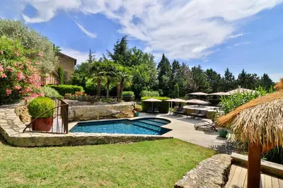 a swimming pool in a yard with a patio at Le Mas de la Lombarde in Lourmarin