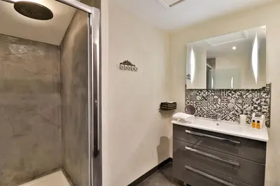 a bathroom with a shower and a sink and a mirror at Le Mas de la Lombarde in Lourmarin
