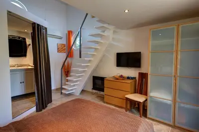 a room with a staircase with a television and a desk at Les Gargoulettes in Lauris