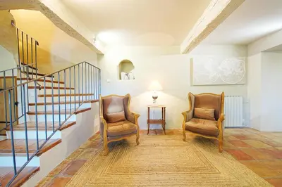 two chairs in a living room with a staircase at Mas des Baussiers in Saint-Martin-de-Castillon