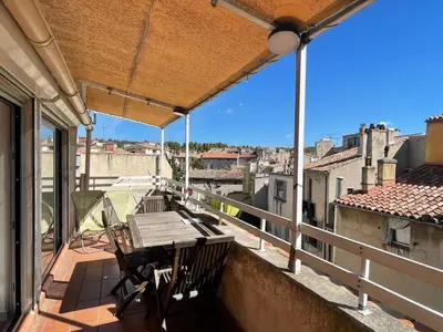 a balcony with a table and chairs on a balcony at Appart Centre Mairie - Terrasse vue Ste Victoire in Aix-en-Provence