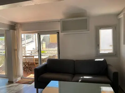 a living room with a couch and a balcony at Appart Centre Mairie - Terrasse vue Ste Victoire in Aix-en-Provence