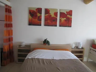 a bedroom with a bed and two paintings on the wall at Lou Cardalines in Bédoin